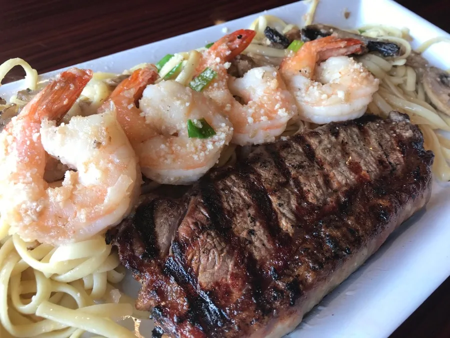 Grilled steak and shrimp over linguine at Bailey's Surf N Turf